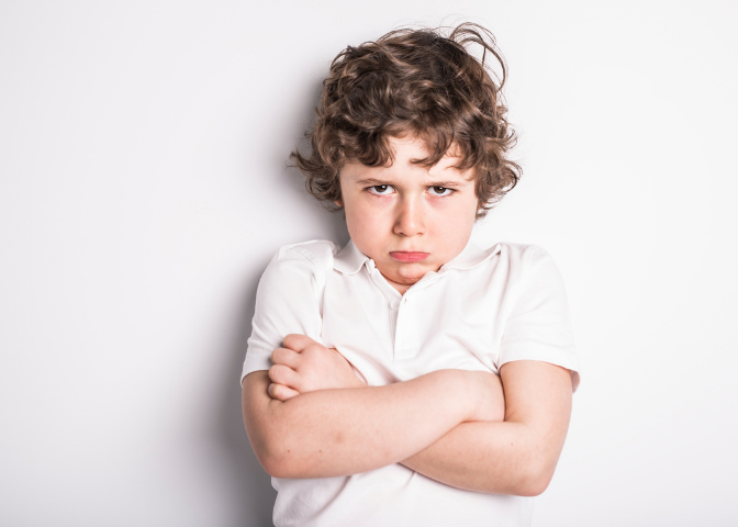 Image of boy pouting with arms crossed