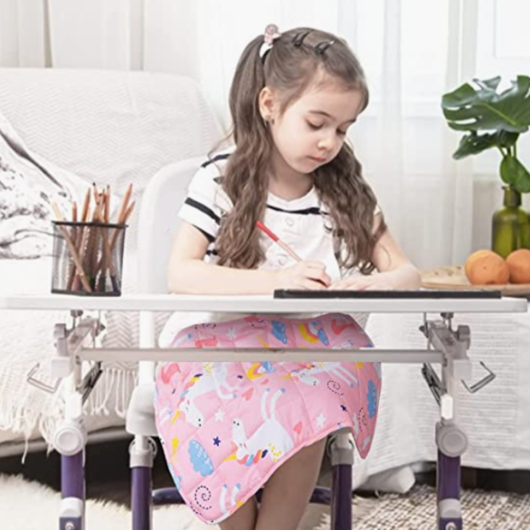 young girl sitting at a small desk, writing